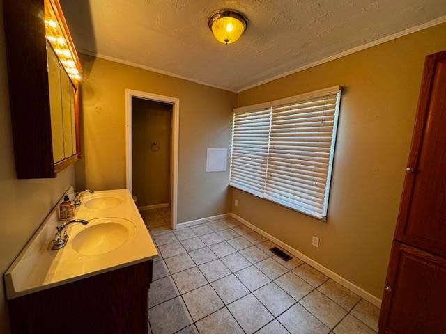 bathroom featuring a sink, visible vents, a textured ceiling, and tile patterned flooring