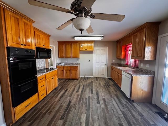 kitchen with black appliances, a sink, dark wood finished floors, brown cabinetry, and ceiling fan