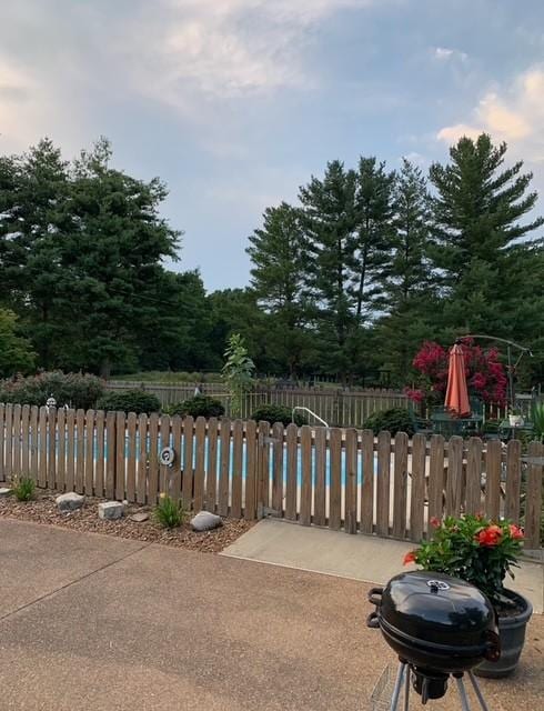 view of swimming pool with fence and grilling area