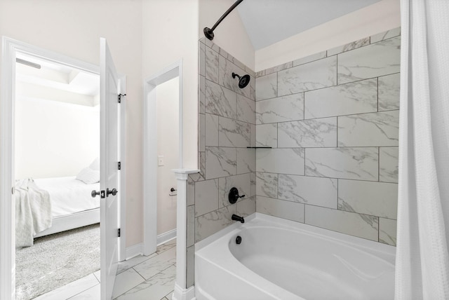 ensuite bathroom featuring baseboards, connected bathroom, shower / bath combo with shower curtain, and marble finish floor