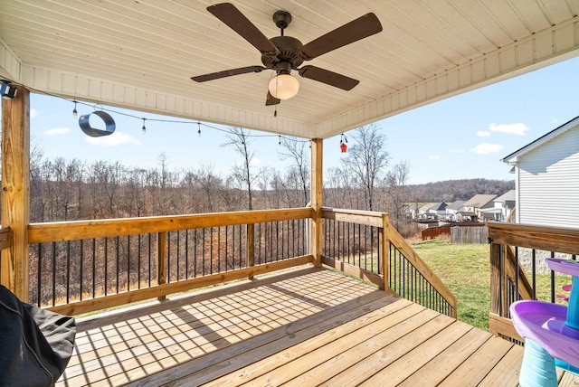 wooden deck featuring a yard, a ceiling fan, and fence