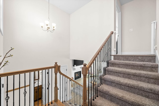 stairs featuring a chandelier, baseboards, and a towering ceiling