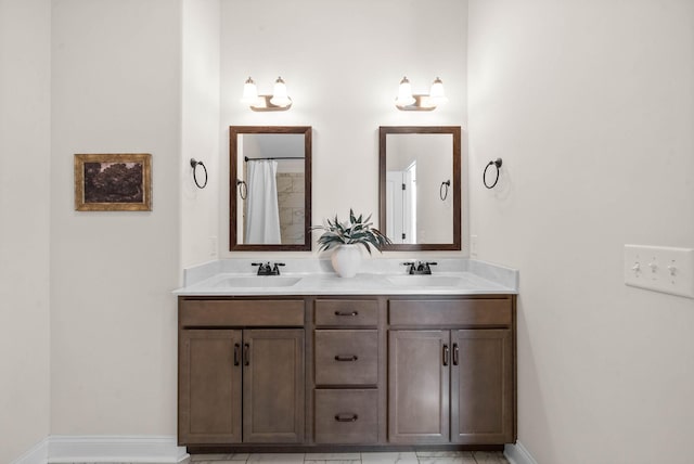 bathroom featuring double vanity, baseboards, and a sink