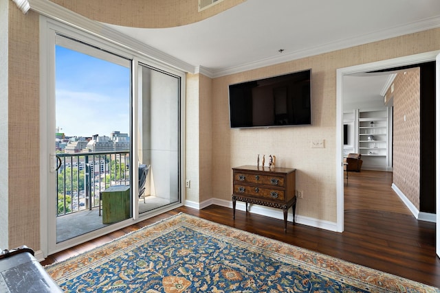 interior space featuring baseboards, wood finished floors, crown molding, and wallpapered walls