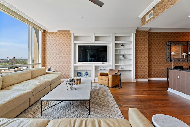 living room featuring wallpapered walls, wood finished floors, baseboards, and ornamental molding