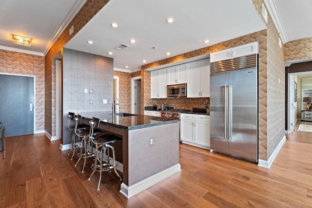 kitchen featuring a sink, visible vents, appliances with stainless steel finishes, and crown molding