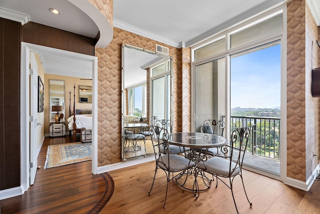 dining space featuring visible vents, baseboards, hardwood / wood-style floors, and crown molding