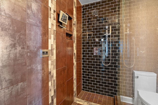 bathroom with toilet and a tile shower