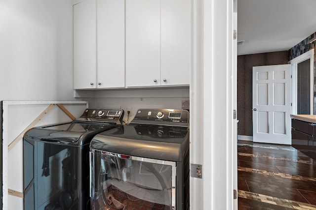 clothes washing area with cabinet space and washing machine and dryer