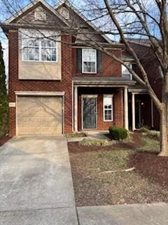 view of front of home with brick siding, an attached garage, and driveway