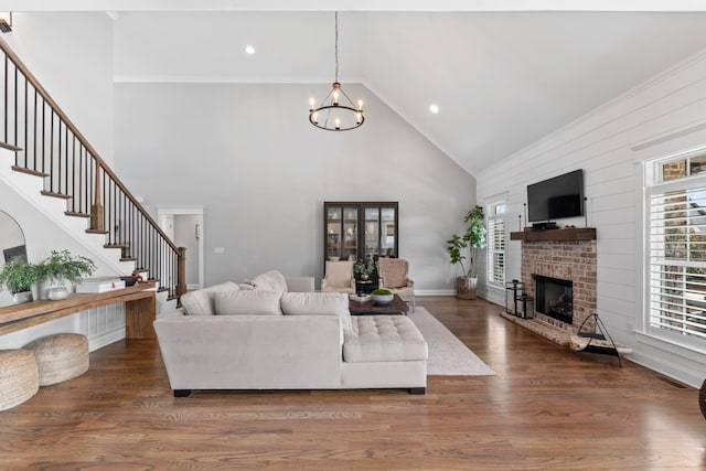 living room featuring a notable chandelier, stairway, plenty of natural light, and wood finished floors