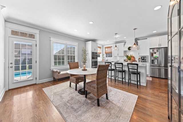 dining space featuring recessed lighting, ornamental molding, and wood finished floors