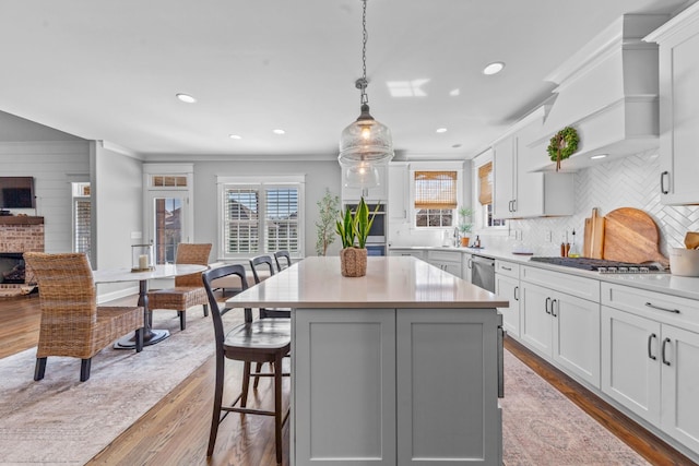 kitchen with appliances with stainless steel finishes, light countertops, and wood finished floors