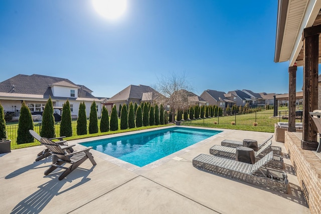 view of pool with fence, a yard, a residential view, a fenced in pool, and a patio area