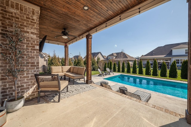 outdoor pool with outdoor lounge area, a patio, a ceiling fan, and fence