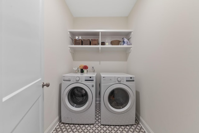 clothes washing area with tile patterned floors, baseboards, washing machine and dryer, and laundry area