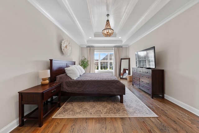 bedroom featuring baseboards, recessed lighting, wood finished floors, a notable chandelier, and a raised ceiling