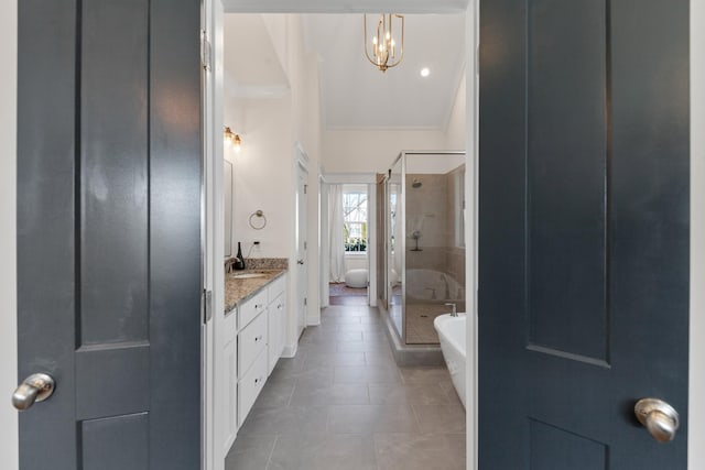 bathroom with vanity, an inviting chandelier, a freestanding tub, a stall shower, and tile patterned flooring