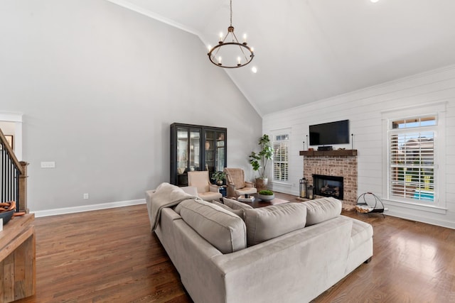 living room with stairs, dark wood-type flooring, a fireplace, and a chandelier