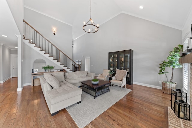 living room featuring baseboards, an inviting chandelier, wood finished floors, and stairs