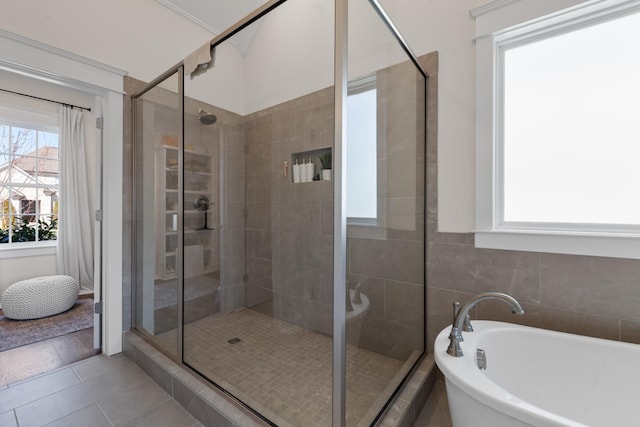 full bath with tile patterned flooring, a stall shower, and a freestanding bath