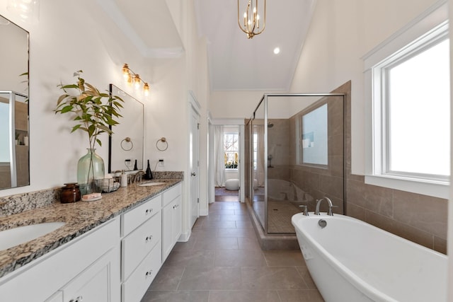 full bath with a shower stall, double vanity, tile patterned floors, and a sink