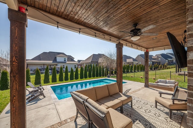 view of swimming pool featuring outdoor lounge area, a patio area, a lawn, and a residential view