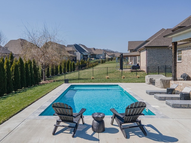 view of swimming pool featuring a fenced in pool, a residential view, a lawn, a fenced backyard, and a patio