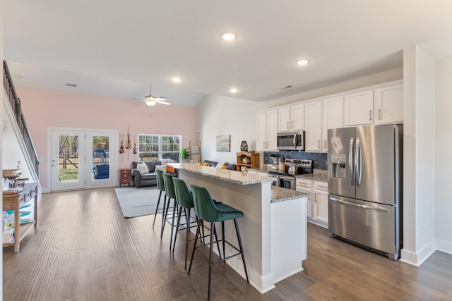 kitchen featuring white cabinetry, a breakfast bar area, appliances with stainless steel finishes, and a center island