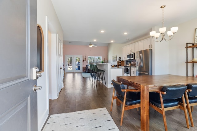 dining space with ceiling fan with notable chandelier, recessed lighting, and dark wood-style flooring