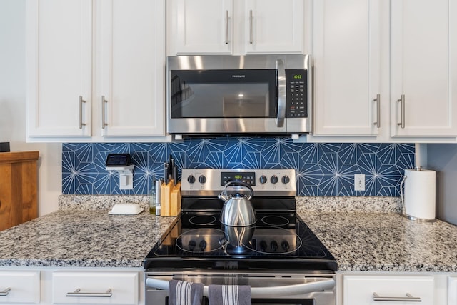 kitchen featuring white cabinets, backsplash, appliances with stainless steel finishes, and light stone counters