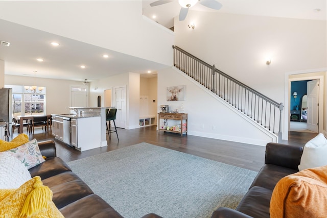 living area with dark wood finished floors, stairway, recessed lighting, and ceiling fan with notable chandelier