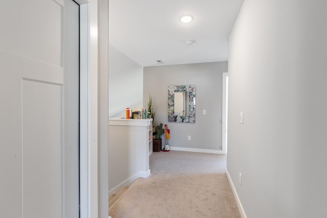 hallway featuring baseboards and carpet floors