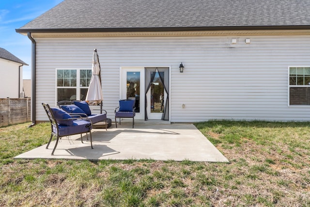 rear view of house featuring a patio area, fence, a lawn, and a shingled roof