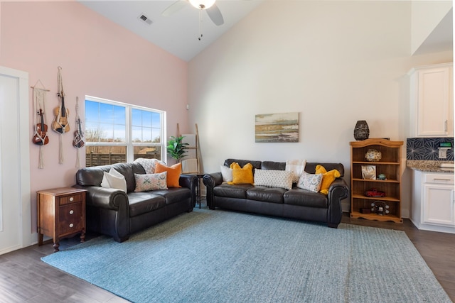 living area featuring visible vents, high vaulted ceiling, dark wood-style flooring, and a ceiling fan