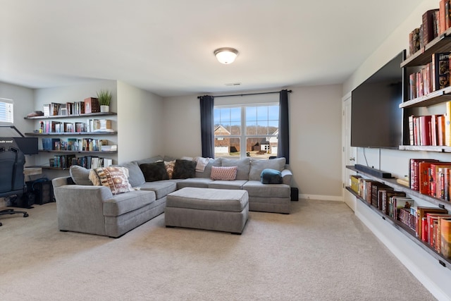 living area with baseboards, plenty of natural light, visible vents, and carpet flooring