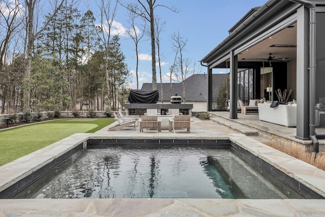 outdoor pool with a patio area, a yard, an outdoor hangout area, and a ceiling fan