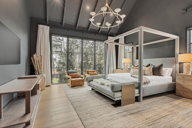 bedroom featuring a notable chandelier, high vaulted ceiling, and hardwood / wood-style floors