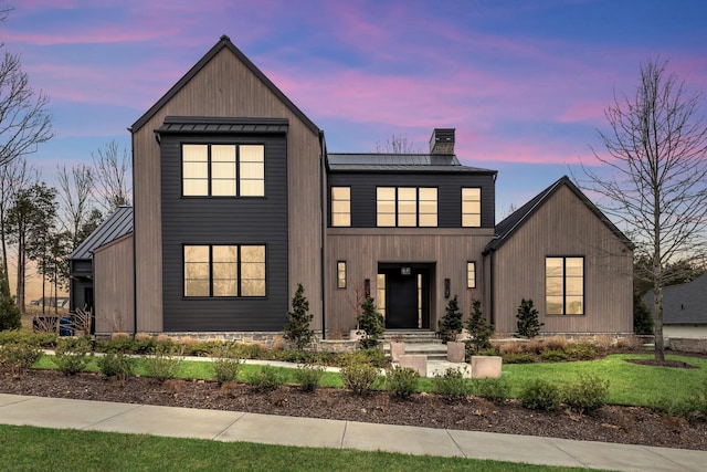 modern farmhouse style home featuring metal roof, a chimney, and a standing seam roof