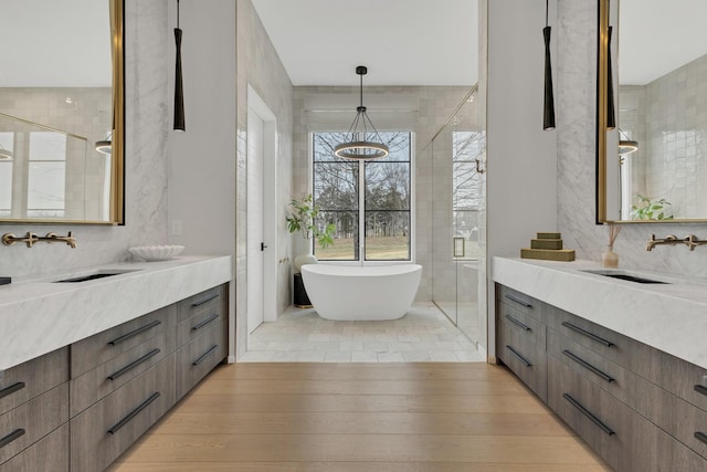 bathroom featuring vanity, a soaking tub, and wood finished floors