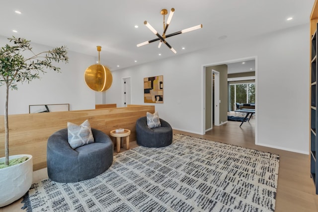 sitting room with wood finished floors, recessed lighting, and baseboards