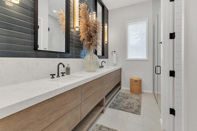 full bathroom with a sink, baseboards, backsplash, and double vanity