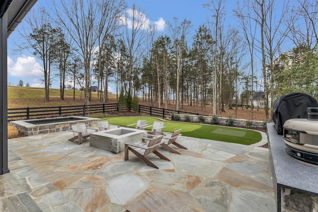 view of patio / terrace featuring an outdoor hot tub, a grill, a fenced backyard, and an outdoor fire pit