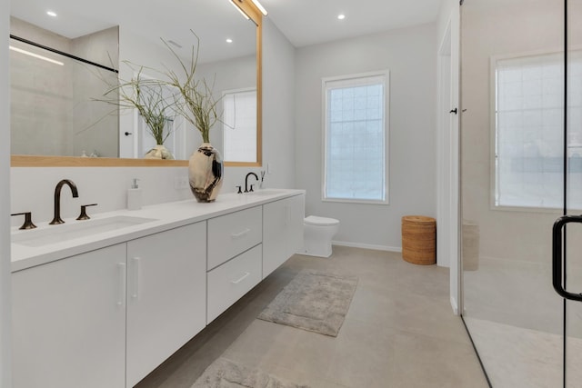 bathroom with double vanity, recessed lighting, a sink, an enclosed shower, and toilet