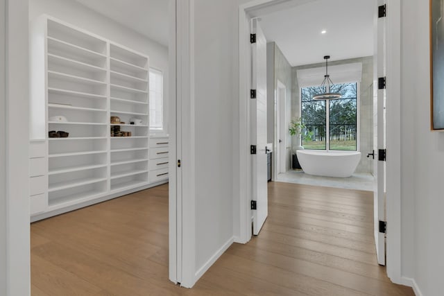 hallway with baseboards and wood finished floors