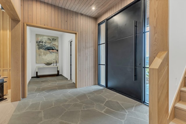 interior space with stone floors, wood walls, and wooden ceiling