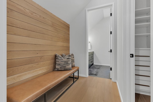 mudroom with wooden walls, baseboards, and light wood-style floors