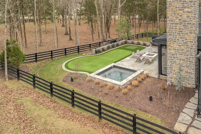 view of yard with an in ground hot tub, a fenced backyard, and a patio area