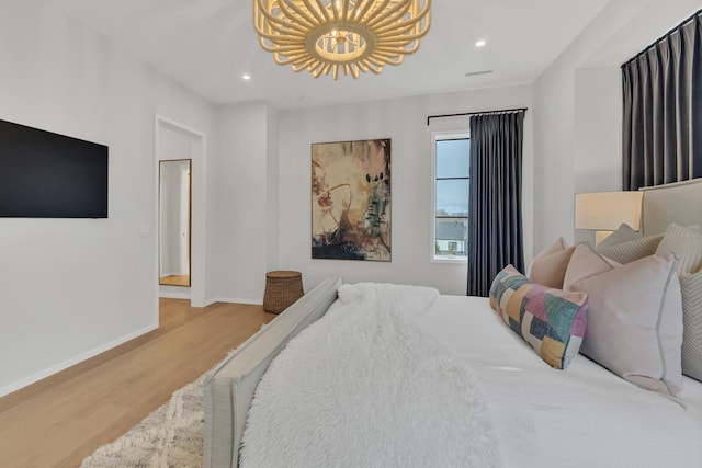 bedroom featuring a chandelier, recessed lighting, baseboards, and wood finished floors