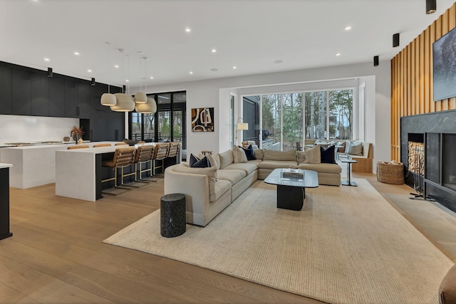 living area featuring a fireplace, recessed lighting, and light wood-style floors